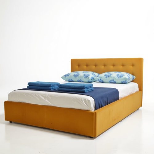 Pat tapițat Karl Mosen cu somieră rabatabilă, ladă de depozitare și saltea – culoare muștar cu perne înflorate